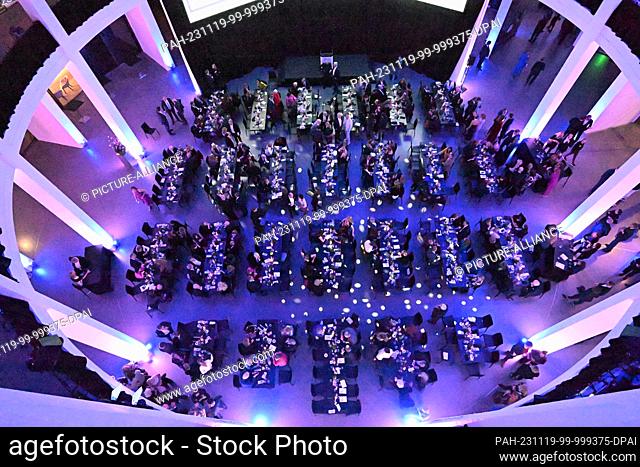 18 November 2023, Bavaria, Munich: Guests celebrate at the ""PIN Benefit Auction 2023"" organized by the Friends of the Pinakothek der Moderne in the Rotunda of...