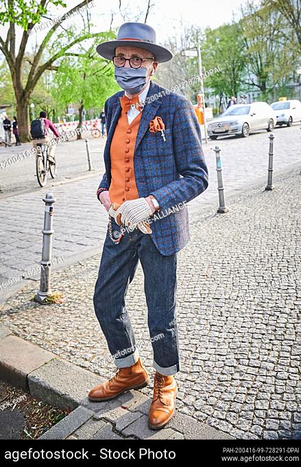 16 April 2020, Berlin: Male model and hipster grandfather Günther Anton Krabbenhöft walks across the Admiralbrücke in Kreuzberg wearing a mouth guard