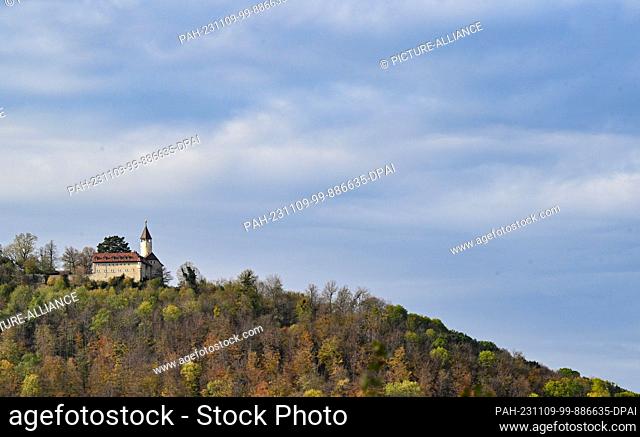 09 November 2023, Baden-Württemberg, Owen: Autumn-colored forest and dark clouds envelop Teck Castle near Owen. Photo: Bernd Weißbrod/dpa