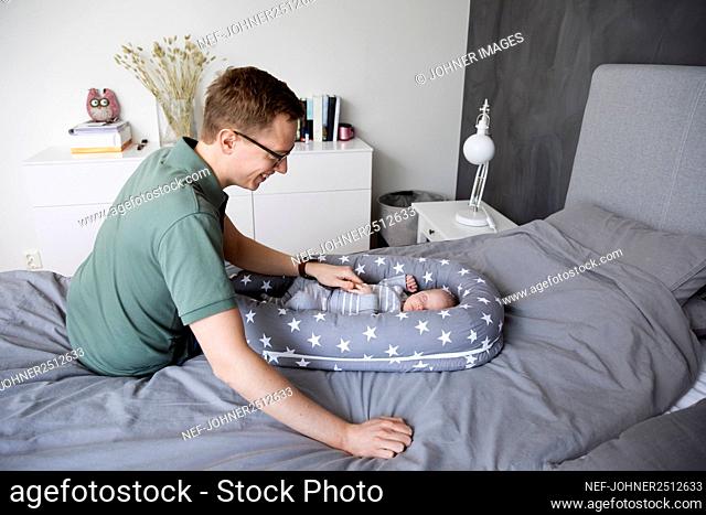 Father putting baby son to sleep