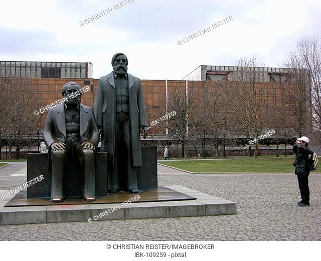 Karl Marx / Friedrich Engels monument in Berlin Mitte, in front of the palace of the Republick (Palast der Republik) , beside a tourist
