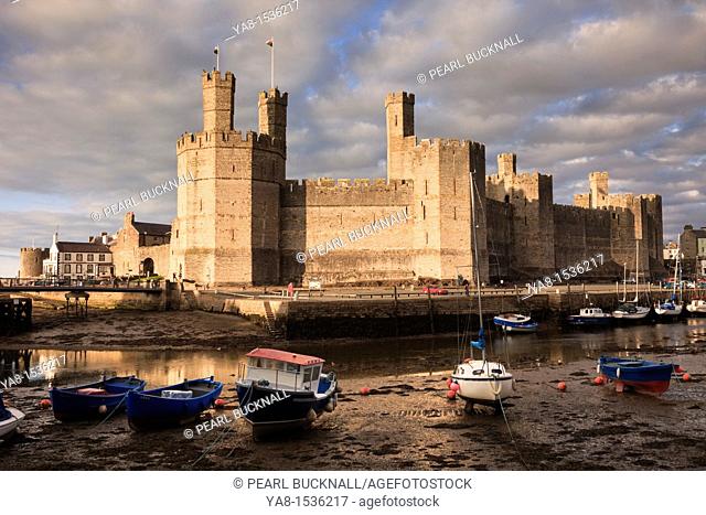 Caernarfon, Gwynedd, North Wales, UK, Britain, Europe  View of Edward 1st 13th century castle across Afon Seiont River estuary at low tide in the evening
