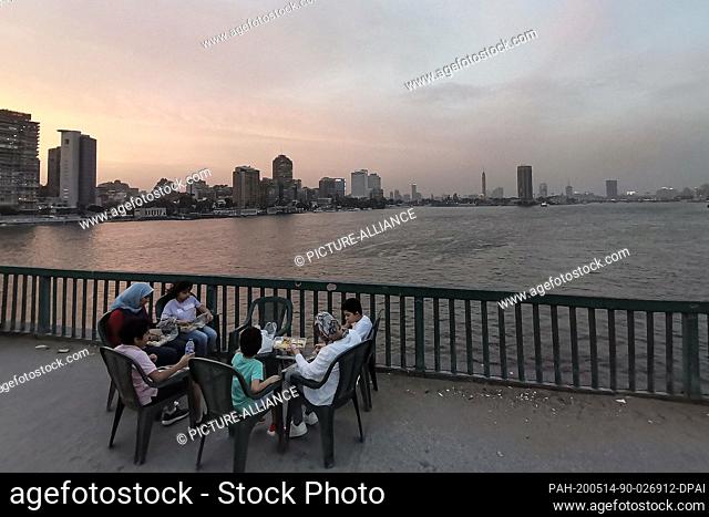 14 May 2020, Egypt, Giza: People gather to have their Iftar (breaking fast) meal on the University Bridge, during the Muslim holy fasting month of Ramadan