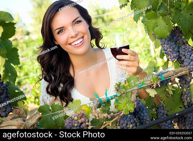 Pretty Mixed Race Young Adult Woman Enjoying A Glass of Wine in the Vineyard