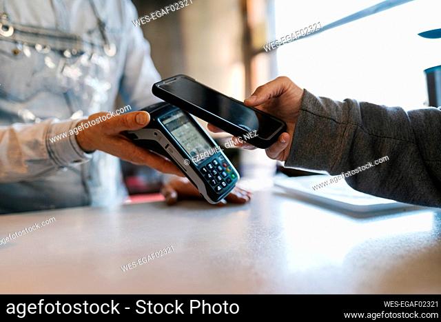 Customer using smart phone for online payment at a bar