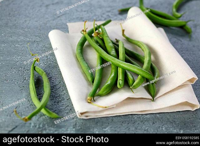 Close up shot of green beans on a grey table.
