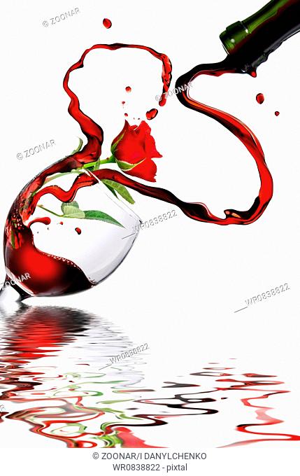 Heart from pouring red wine in goblet isolated on white