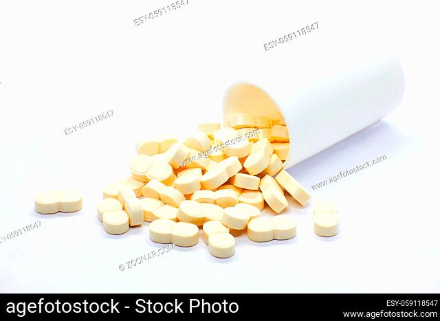 pills coming out of bottle on white background
