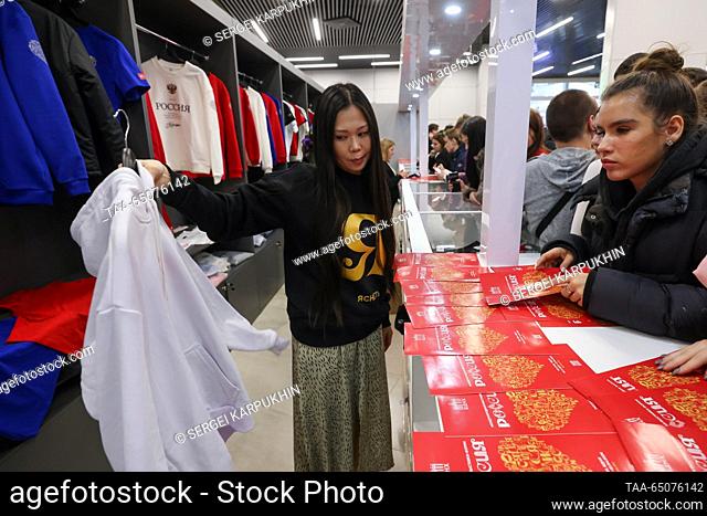 RUSSIA, MOSCOW - NOVEMBER 22, 2023: A woman shows a hoodie for sale with a quote from Russia's President Putin during the Russia Expo international exhibition...