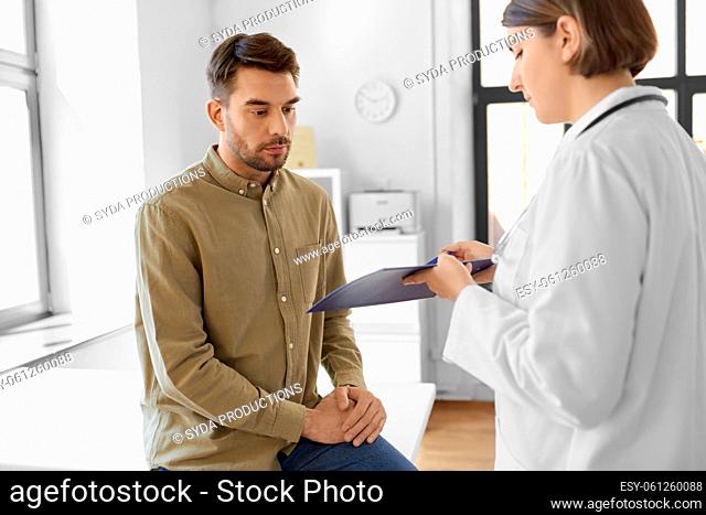doctor showing clipboard to patient at hospital