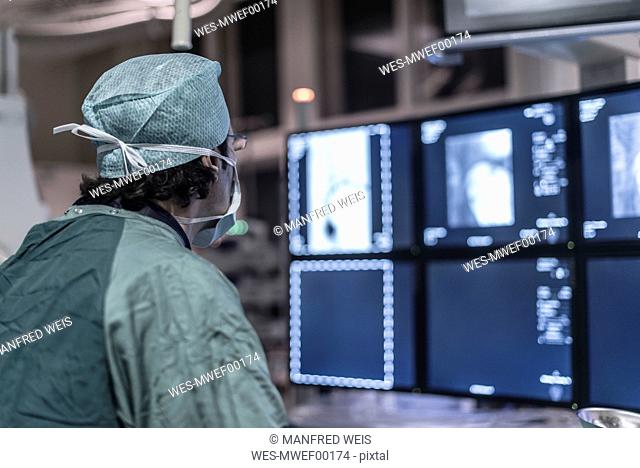 Neuroradiologist in scrubs looking at monitor
