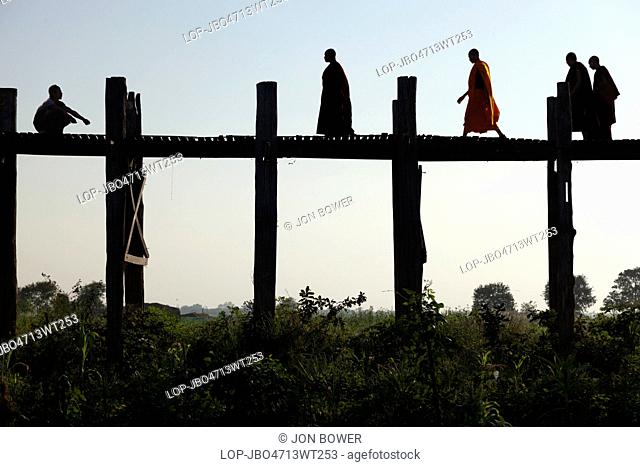 Myanmar, Mandalay, Lake Taungthaman. Monks Crossing U Bein Teak Bridge across Taungthaman Lake in Myanmar