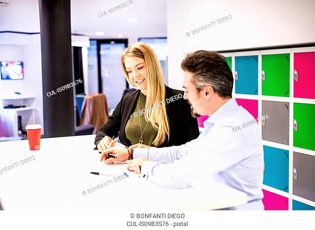 Businesswoman and man having brainstorming meeting in office