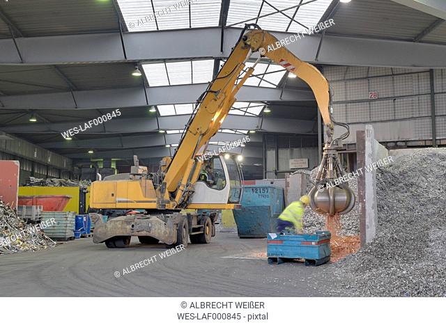 Excavator in a scrap metal recycling plant