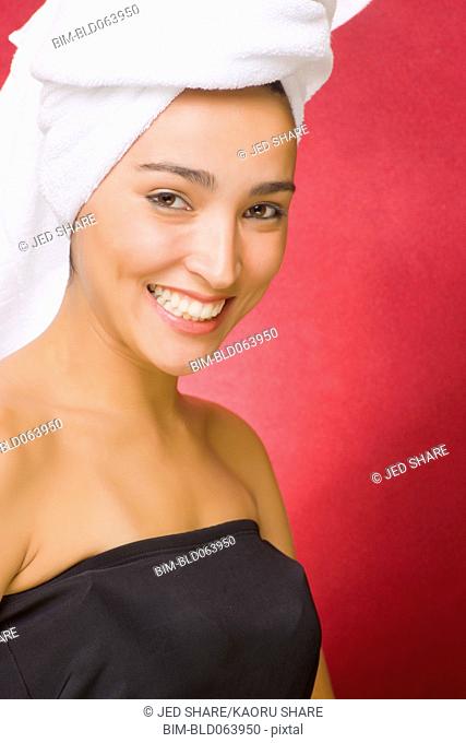 Hispanic woman with hair wrapped in towel