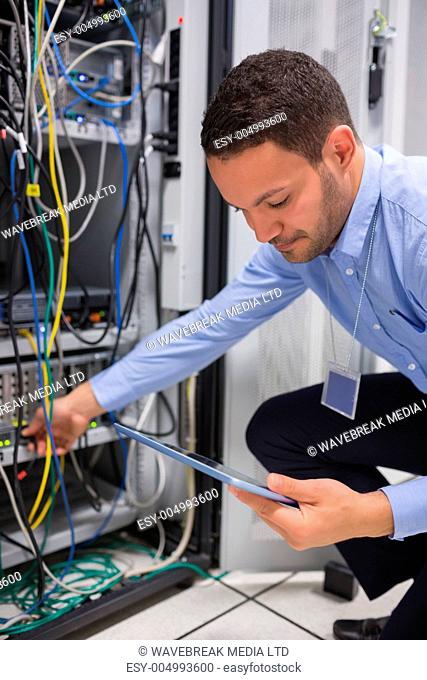 Man using tablet pc to work on servers in data center