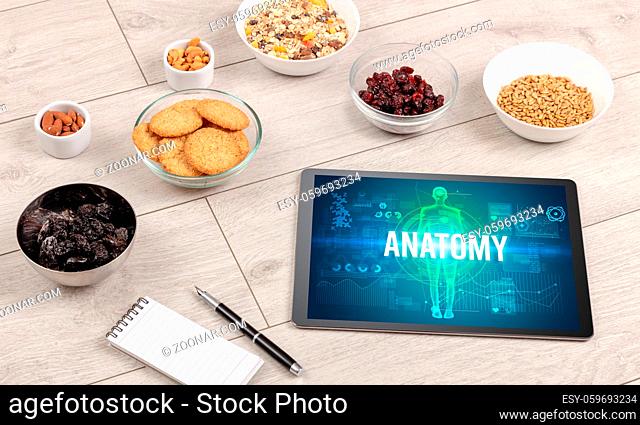 ANATOMY concept in tablet with fruits, top view