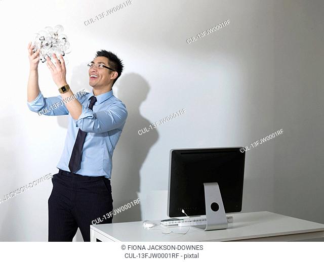 Business man holding Light bulbs