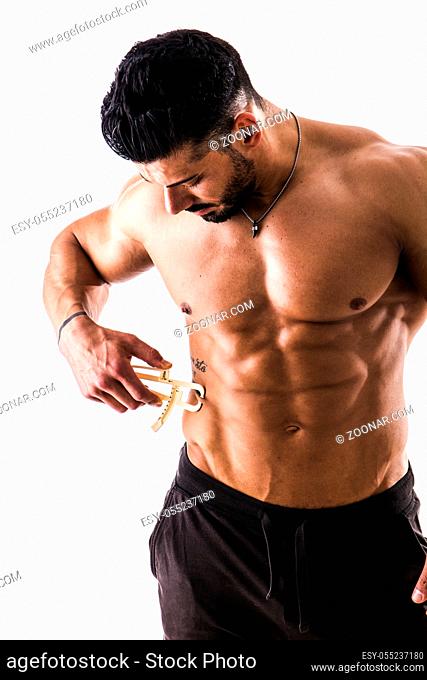 Handsome muscular and shirtless male using plicometer on white background