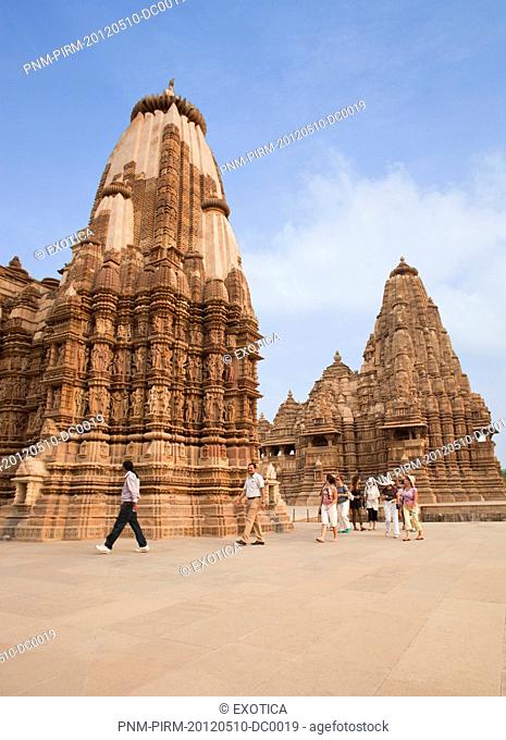 Tourists admiring the architecture of a temple, Lakshmana Temple, Khajuraho, Chhatarpur District, Madhya Pradesh, India