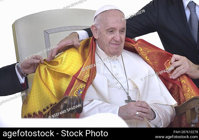 An Indian priest covers the shoulders of Pope Francis with a yellow shawl, a symbol of respect and honor..Pope Francis during a weekly general audience at Saint...