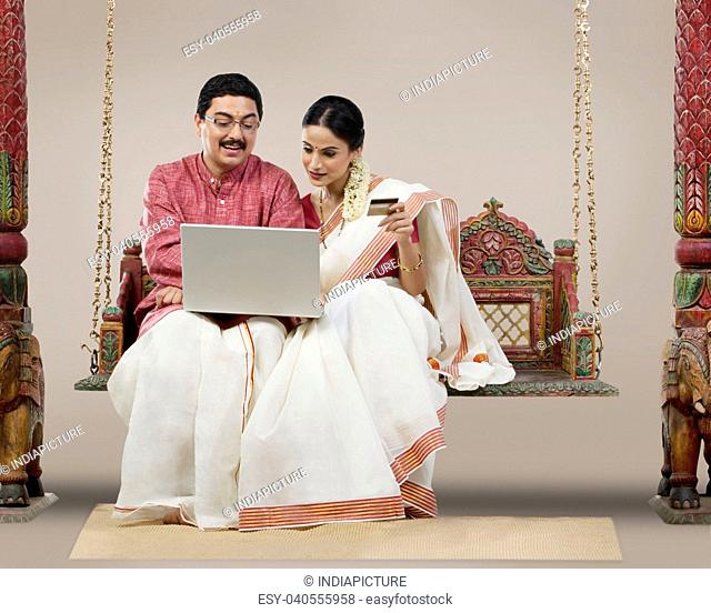 South Indian couple with a laptop and credit card