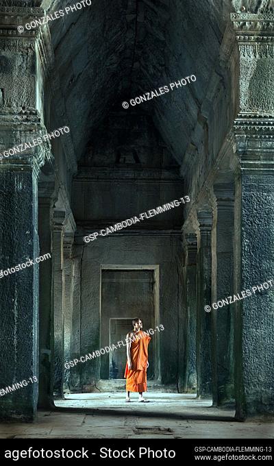 Siem Reap, Cambodia - January 19, 2011: A monk in his orange robe walking inside the Angkor Wat complex