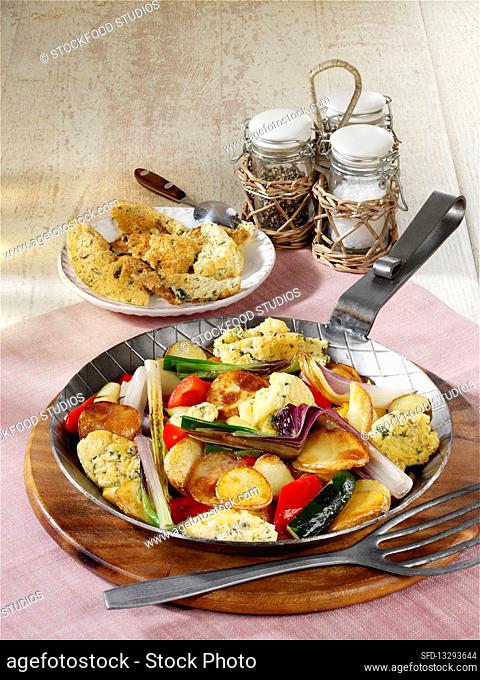Fried potatoes with pancakes, Mediterranean vegetables and cheese