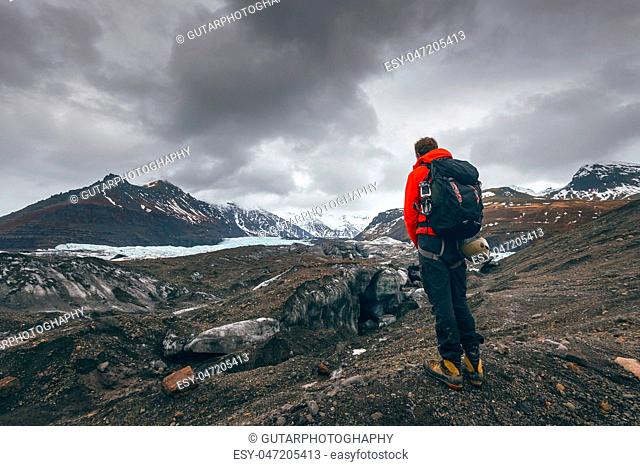 Hiking adventure travel man watching glacier in Iceland