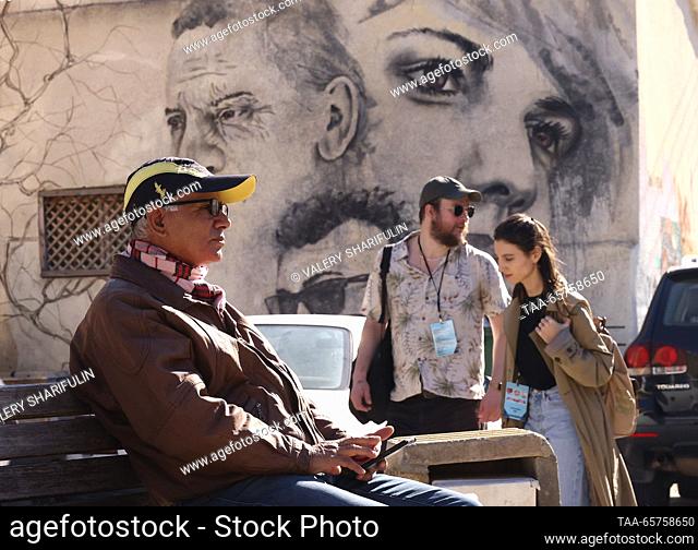 CYPRUS, NICOSIA - DECEMBER 14, 2023: A man rests on a bench, a mural featured on one of the city's streets. The Turkish Republic of Northern Cyprus is a de...