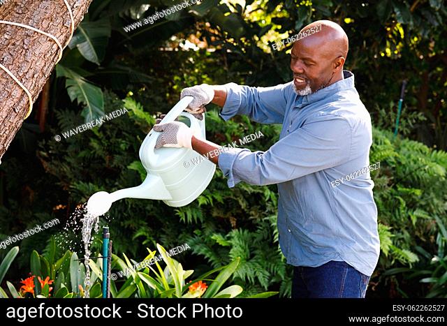 Happy senior african american man working in garden