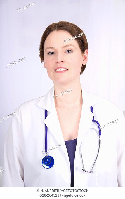 Smiling woman doctor in white overall with blue stethoscope