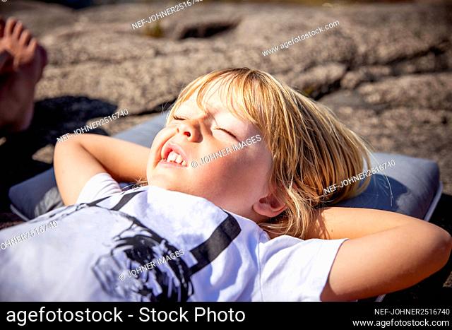 Boy making faces and sunbathing