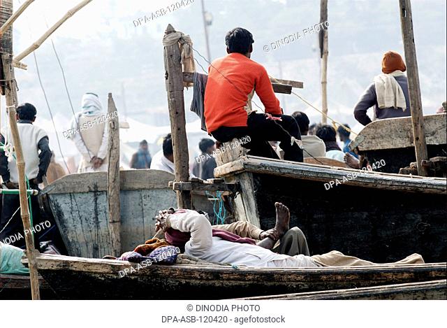 Devotee take nap on boat at confluence of Ganges; Yamuna and Saraswati rivers to take holy dip during Ardh Kumbh Mela ; Allahabad ; Uttar Pradesh ; India