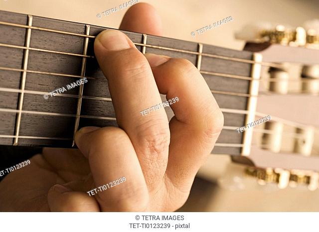 Close up of man's hand playing guitar