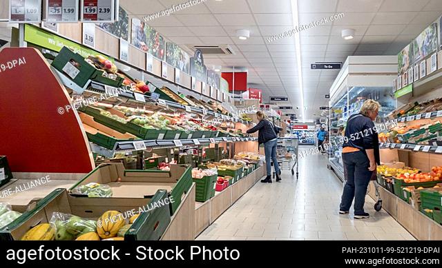 10 October 2023, Hamburg: Customers look at the range of vegetables and fruit on offer in a LIDL store, which is usually located directly at the entrance