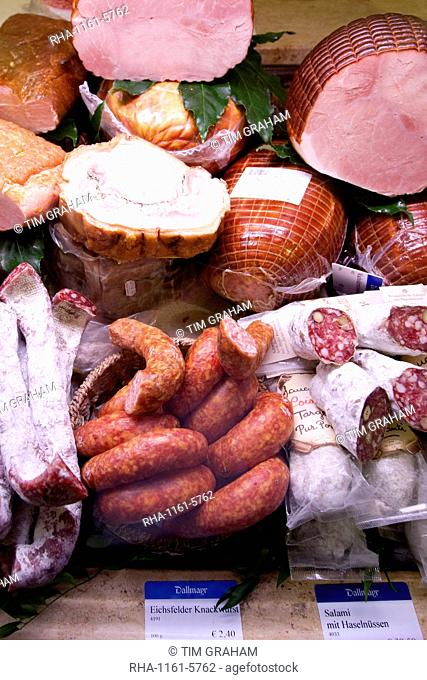 Shop display of cured meats, hams, pork sausages, salami, at Dalmayr food shop and delicatessen in Munich, Bavaria, Germany