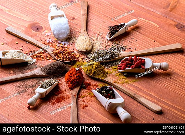 assortment of diferent color spices on wooden table