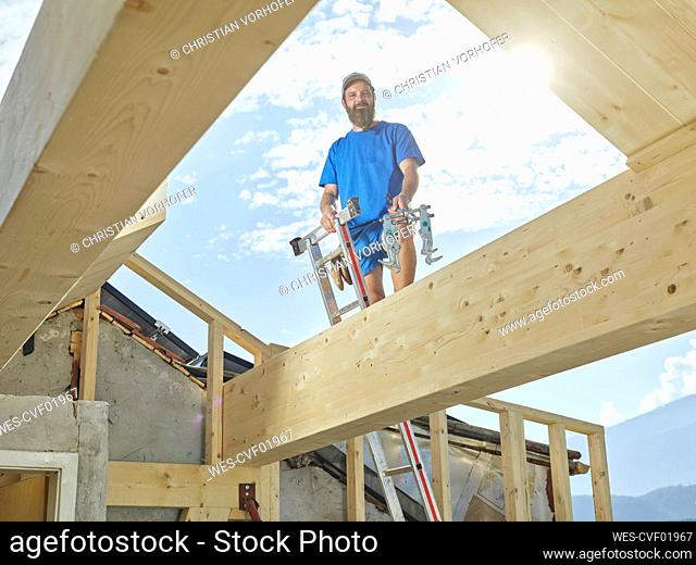 Young man standing on ladder at construction site