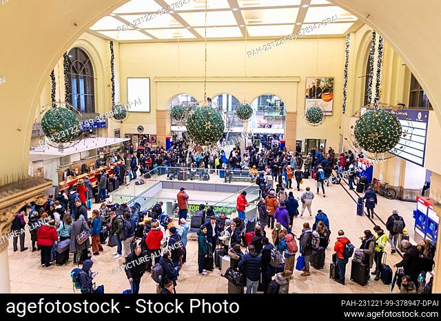 21 December 2023, Lower Saxony, Hanover: Numerous travelers wait in front of an information desk at the main station in the evening