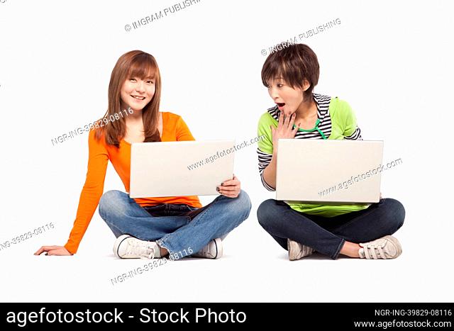 Two friends using laptop computers