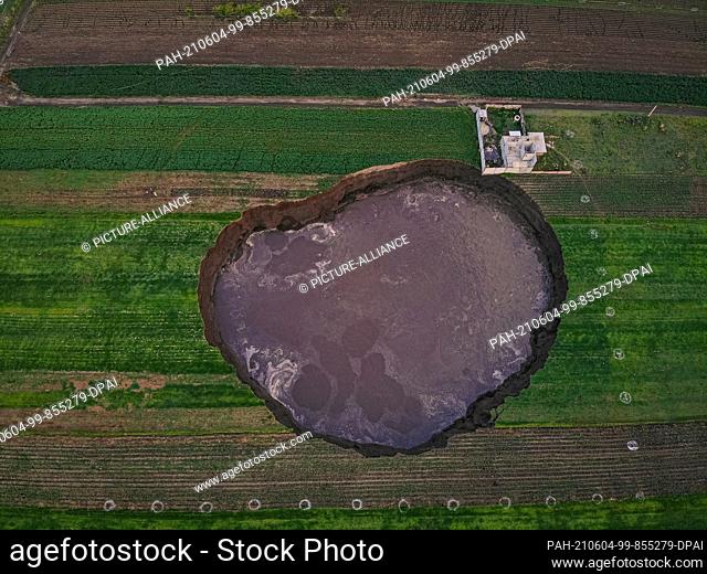 02 June 2021, Mexico, Santa Maria Zacatepec: From a bird's eye view, a large crater filled with water can be seen. (to dpa ""Huge crater in Mexico puzzles"")...