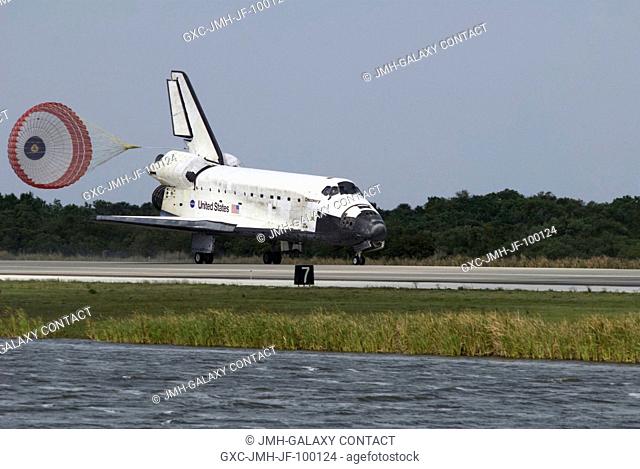 Space Shuttle Discovery's drag chute is deployed as the spacecraft rolls toward wheels stop on Runway 15 of the Shuttle Landing Facility at NASA's Kennedy Space...