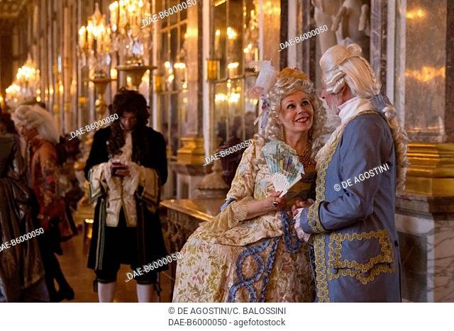 A man and a woman having a conversation in the Hall of Mirrors, courtship party (Fete galante) with participants wearing clothes from the Louis XIV period