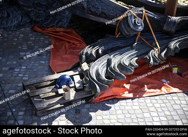 04 April 2023, Berlin: Tools and a helmet lie on a pallet next to the cartouche. The huge cartouche with coat of arms is being installed above the Eosander...