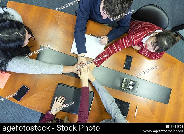 Business people showing team work and giving five in office. Teamwork concepts
