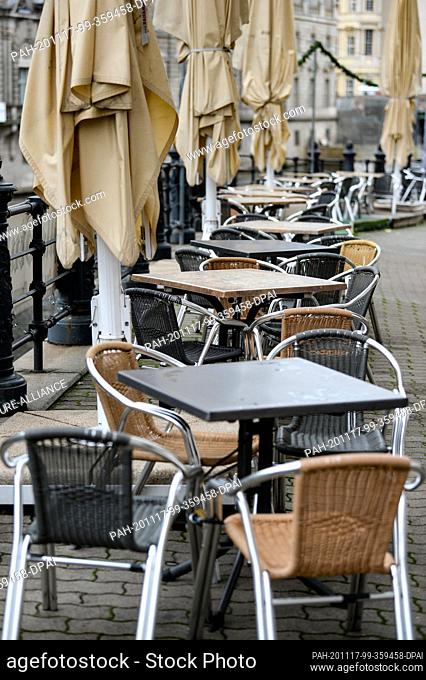 16 November 2020, Berlin: Empty tables and folded parasols are standing in front of a restaurant in the Nikolai quarter. Federal and state governments have...