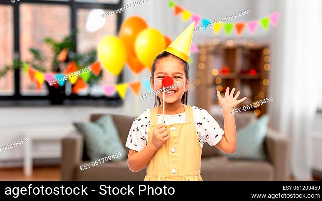 girl with red clown nose at birthday party at home