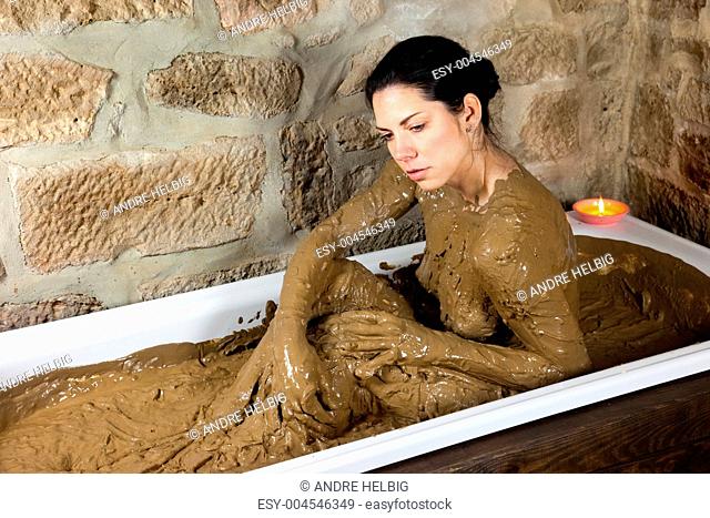 Frau in Badewanne mit Lehm