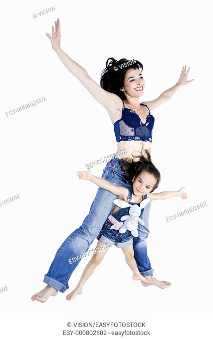 beautiful woman playing with her little girl on studio white background